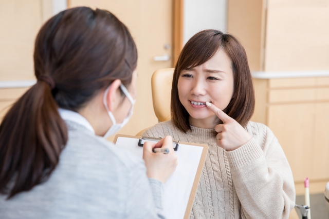 歯の痛みを歯科医師に相談する女性